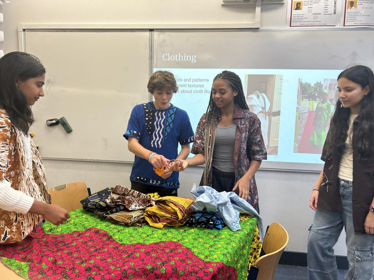 Students attend an African Caribbean Culture club meeting during lunch Oct. 17. Club co-leader Khady Sao (’27) shared traditional African clothing and jewelry with members. 